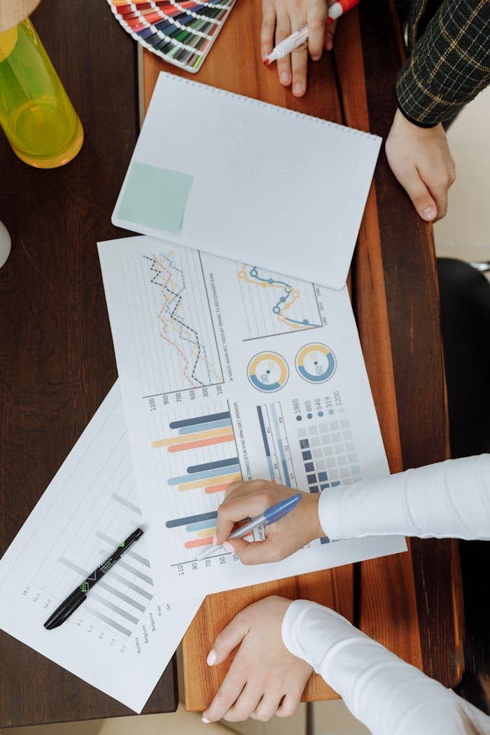 Crafting Captivating Headlines: Your awesome post title goes here Top view of business team analyzing charts and data on paper for strategic planning.